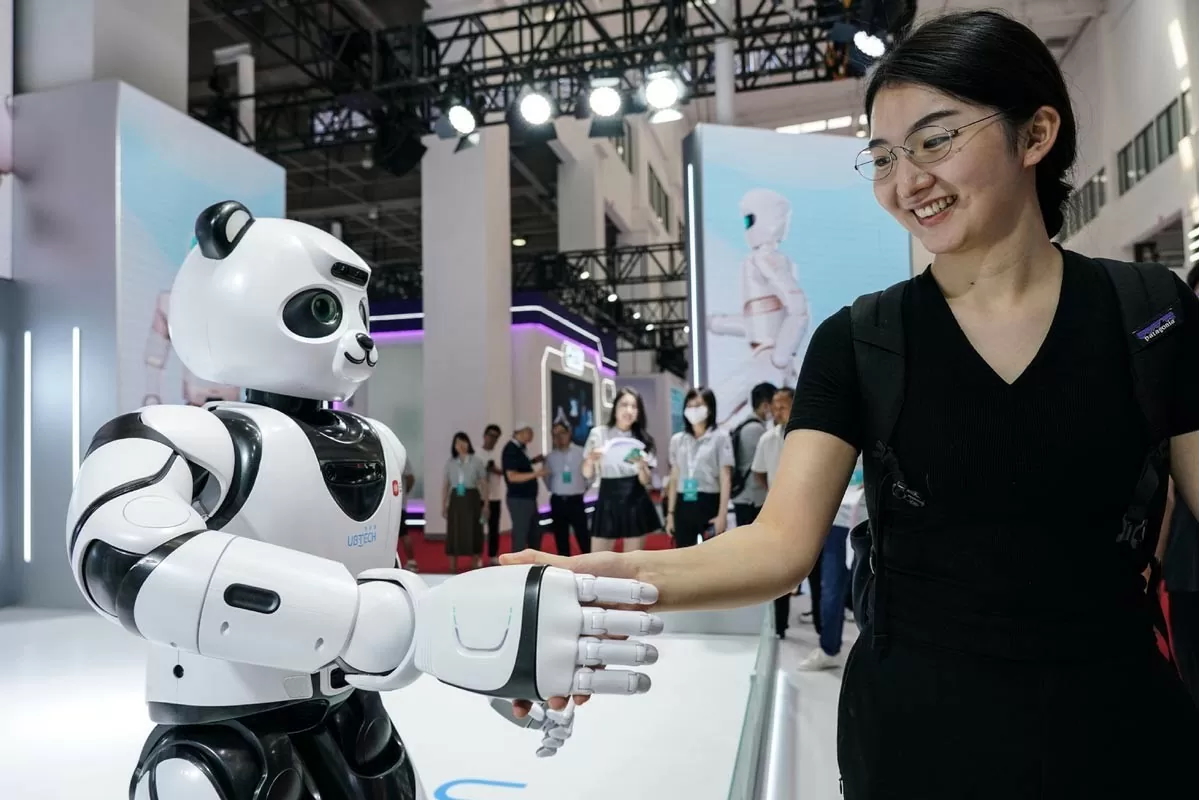 Des visiteurs interagissent avec un robot lors de la Conférence mondiale sur les robots 2023 à Pékin, en Chine, le 16 août 2023. © Xinhua