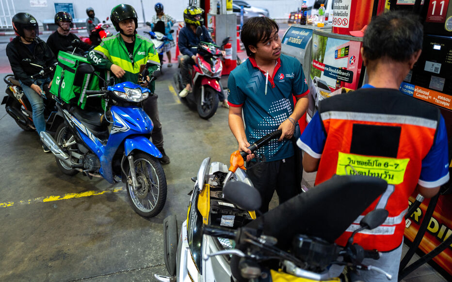 Des motards font la queue pour faire le plein de carburant dans une station-service en plein conflit américano-israélien avec l'Iran, à Bangkok, Thaïlande, le 26 mars 2026.